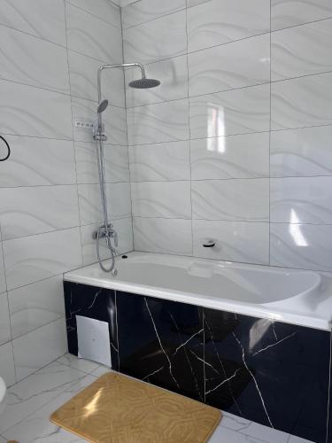 a white bathroom with a tub and a shower at Sedudu Turn Cottages in Maun