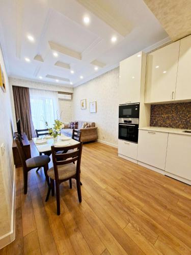 a kitchen and living room with a table and chairs at Spacious Riverside Apartment in Central Tbilisi with Balcony in Tbilisi City