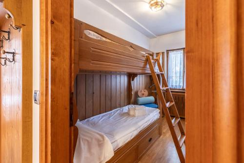 a bunk bed with a ladder in a room at Casa Amalia, with panoramic terrace in Cortina dʼAmpezzo