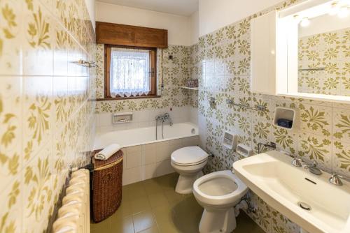a bathroom with a toilet and a sink and a tub at Casa Amalia, with panoramic terrace in Cortina dʼAmpezzo
