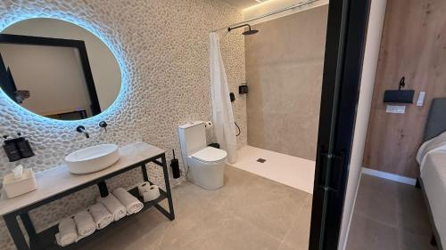 a bathroom with a sink and a toilet and a mirror at Bormujos Suites Sevilla in Bormujos