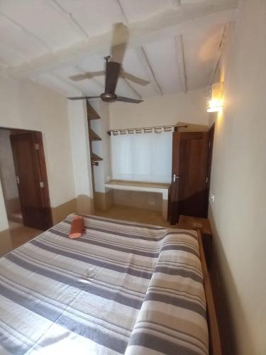 a bed in a room with a ceiling fan at Marlin room in Watamu