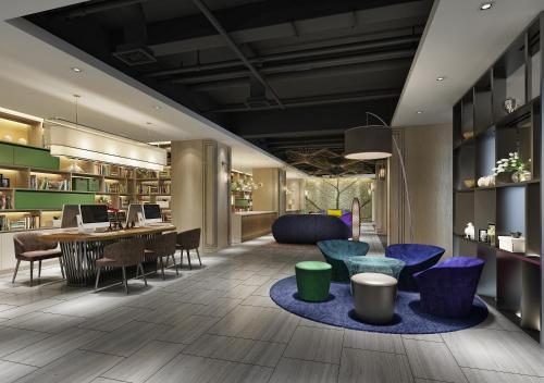 um átrio com cadeiras e mesas e uma biblioteca em Ibis Styles XM Zhongshan Hotel em Xiamen