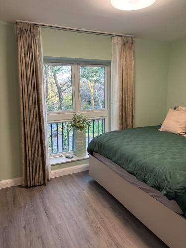 a bedroom with a bed and a large window at Petite Apartment in Denham in Denham