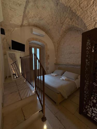 a bedroom with a bed and stairs in a building at Il Balcone di Anna - Luxury Homes in Ceglie Messapica