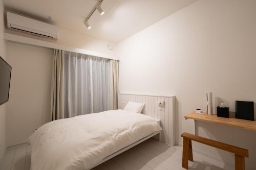 a bedroom with a white bed and a window at stella stay in Imari