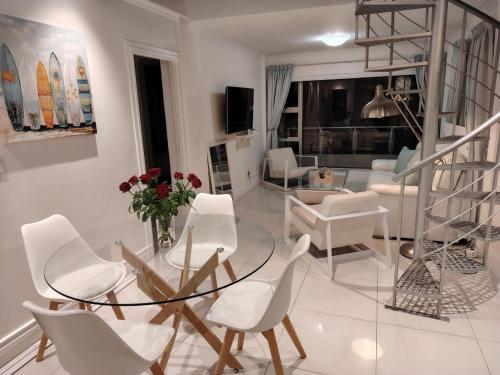a living room with a glass table and white chairs at Atlantic Canvas - Mountain and Sea in Cape Town