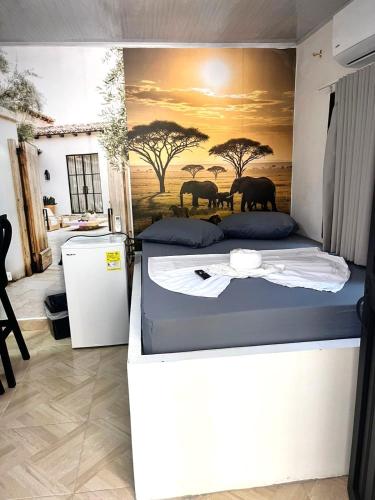 a bedroom with two beds and a painting of elephants at Sabana Africana in Puerto Triunfo
