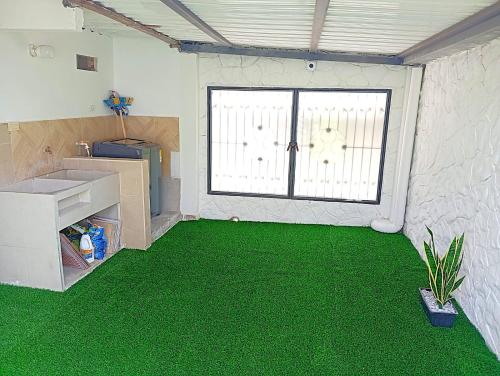 a room with a green floor and a window at Sabana Africana in Puerto Triunfo