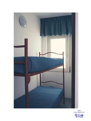 two bunk beds in a room with a window at B&B Corte degli Ulivi in Mattinata