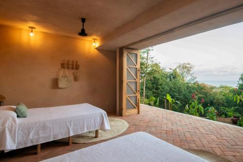 a bedroom with a bed and a large window at Monte LaLaLa - Eco Lodge in Mermejita in Mazunte
