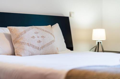 a bedroom with a bed with a pillow and a lamp at GuestReady - Charming Apartment with Ocean Views in Caniço