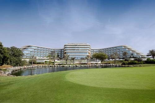 a golf course in front of a large building at JA Lake View Hotel, Dubai in Dubai