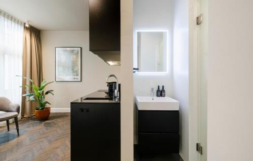 a kitchen with a sink and a counter top at Hotel Bloemendaal by BHC in Bloemendaal