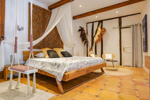 a bedroom with a bed with a canopy at LE PRIEURE - Suites romantiques spa privatif, piscine, jardin, massages proche de Toulouse in Verfeil