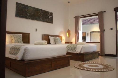 a bedroom with two beds and a mirror at Selong Holiday in Selong Belanak