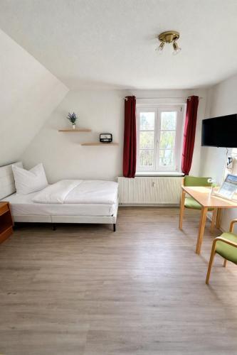 a bedroom with a bed and a table and a window at Schlösschen am Rhinufer in Alt Ruppin