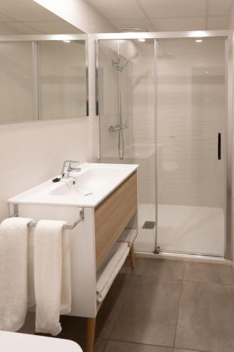 a bathroom with a sink and a shower at Es Mitjorn Hotel in San Antonio