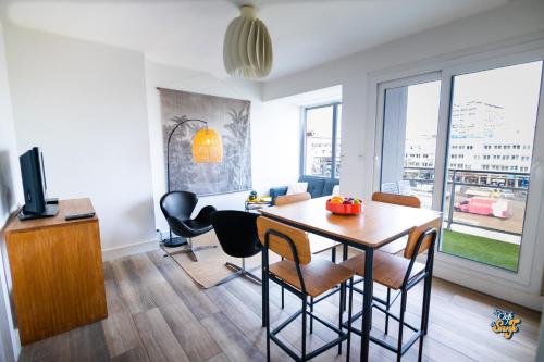 a living room with a dining room table with chairs at La Loge de la Tour in Calais
