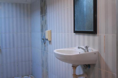 a bathroom with a sink and a mirror on the wall at Selong Holiday in Selong Belanak