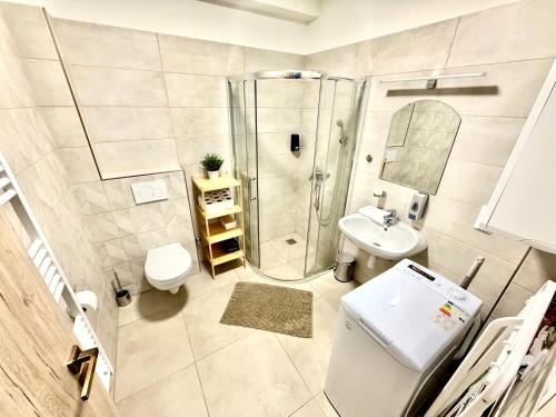 a bathroom with a shower and a toilet and a sink at Ady Corner Prémium Apartmanok - Siófok in Siófok
