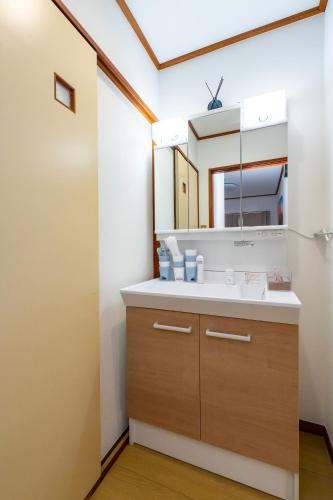 a bathroom with a sink and a mirror at Holiday Home 3 Floors 115 m Near Haneda Airport 6 Bedrooms Sleeps 9 in Tokyo