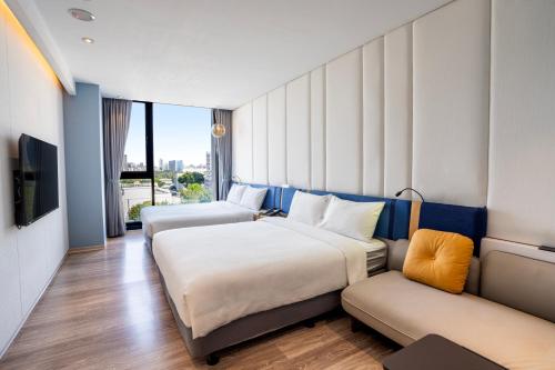 a hotel room with two beds and a couch at Explore Hotel in Taichung
