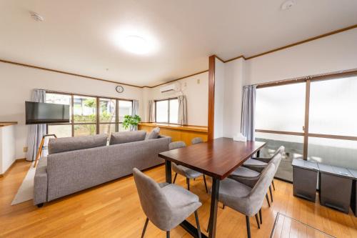 a living room with a couch and a table and chairs at Holiday Home 3 Floors 115 m Near Haneda Airport 6 Bedrooms Sleeps 9 in Tokyo