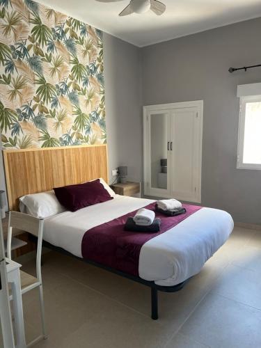a bedroom with a large bed with towels on it at Almendra B Vitalba Apartments in Lanjarón