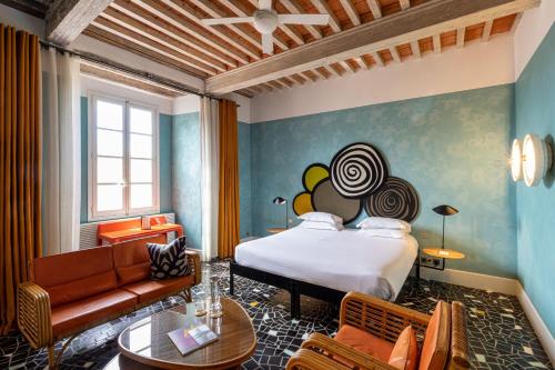 a hotel room with a bed and a couch at Le Cloître in Arles
