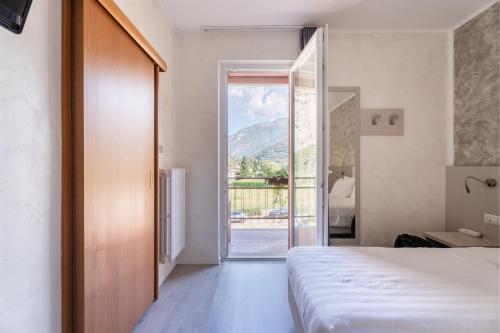 ein Schlafzimmer mit einem Bett und einer Glasschiebetür in der Unterkunft Hotel Angelini in Nago-Torbole