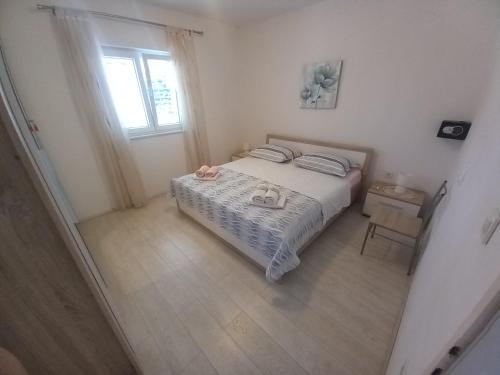 a small bedroom with a bed and a window at Vila Neve 87 Apartman in Veliko Brdo