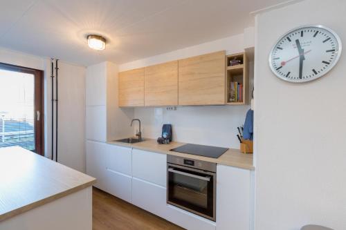 a kitchen with a large clock on the wall at Welcome in - Appartement met balkon in Veere I Kievitenlaan 22 in Veere