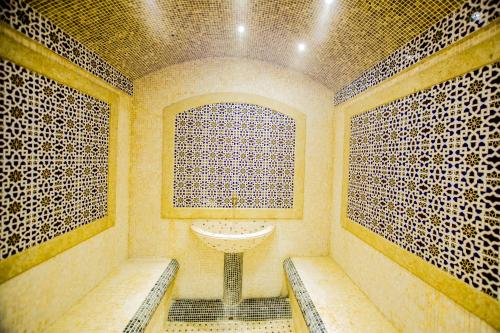 a bathroom with a sink and benches in a room at City Palace Hotel Tashkent in Tashkent