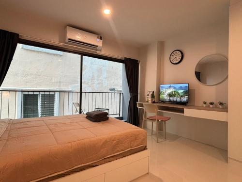 a bedroom with a bed and a large window at 4 mins to MRT Sutthisan in Bangkok