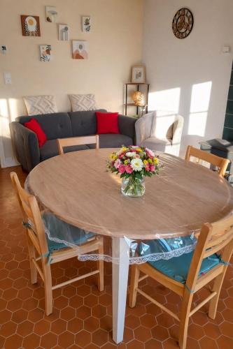 een woonkamer met een tafel waarop een vaas met bloemen staat bij La source in Le Grand-Pressigny