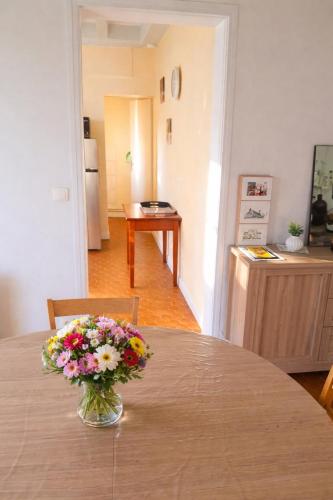 een vaas met bloemen op een tafel in een kamer bij La source in Le Grand-Pressigny
