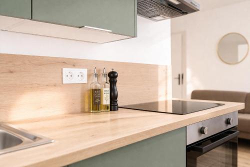 a kitchen counter with two bottles of wine on it at Immeuble privatif 3 logements et 1 logement non loin de l'immeuble in Le Portel