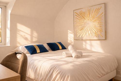 a bedroom with a white bed with blue and yellow pillows at Immeuble privatif 3 logements et 1 logement non loin de l'immeuble in Le Portel
