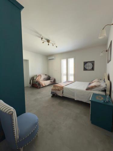 a bedroom with two beds and a chair in it at Casa della Cittadella in Noto