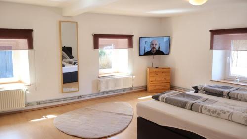 a bedroom with two beds and a tv on the wall at Haus Wangen in Dürler
