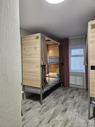 a room with a bunk bed and a large window at Qonaq Hostel in Astana