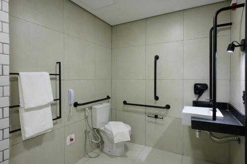 a bathroom with a toilet and a sink at Ibis Caruaru in Caruaru
