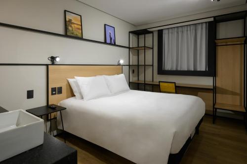 a large white bed in a hotel room at Ibis Caruaru in Caruaru