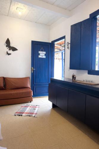 a kitchen with blue cabinets and a brown couch at Sonho de Minas Hospedaria in Ouro Preto