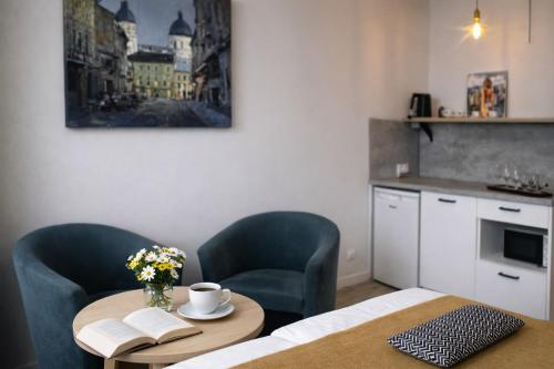 a kitchen with a table and two chairs and a table with flowers at Apart-HOTEL GALLERY 21 in Lviv