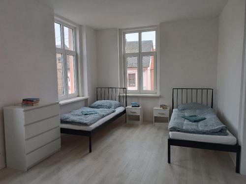two beds in a room with two windows at Apartmány MARTIN SARVAŠ in Tachov