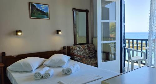 a bedroom with a bed with a view of the ocean at Remezzo Guesthouse in Agios Ioannis Pelio