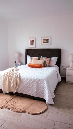 a bedroom with a large white bed with orange pillows at Ankara Residence in Santo Domingo