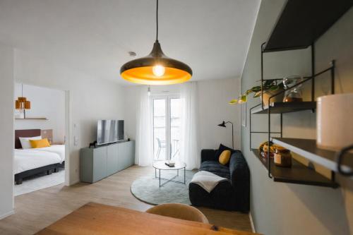 a living room with a couch and a bedroom at LIVELY am Kaiserberg Duisburg in Duisburg